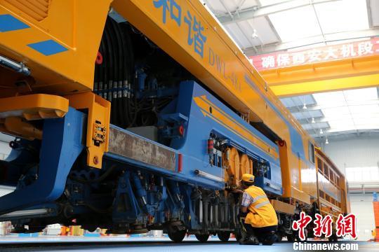 圖為工人正在清理大型養(yǎng)路機械?！堖h 攝